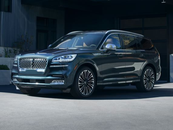 En mörkblå familje-SUV parkerad framför ett modernt hus.